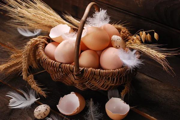 Ovos de fazenda em cesta de vime no fundo de madeira — Fotografia de Stock