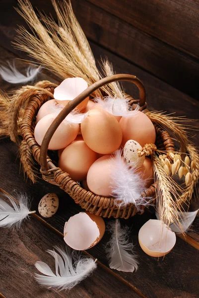 Farm eggs in wicker basket on wooden background — Stock Photo, Image