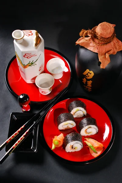 Sushi maki em placa vermelha e sake — Fotografia de Stock