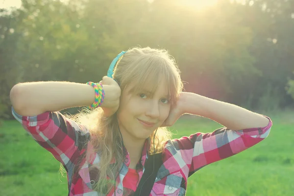 Girl listening music on the meadow in vintage style — Stock Photo, Image