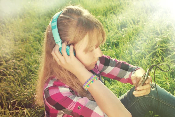Girl listening music on the meadow in vintage style — Stock Photo, Image