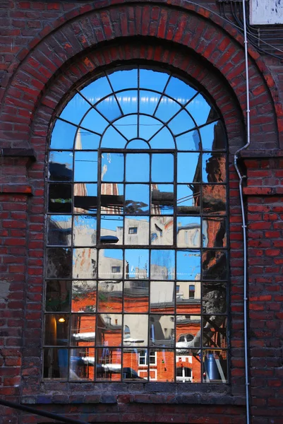 Reflexão de edifícios na antiga janela da fábrica em Lodz — Fotografia de Stock