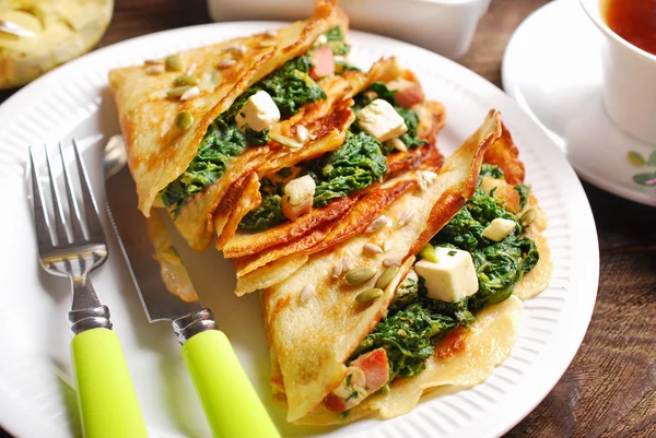 Spinach and feta filled pancakes on wooden table — Stock Photo, Image
