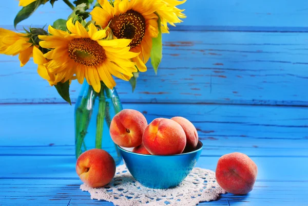 Fresh peaches and sunflowers — Stock Photo, Image