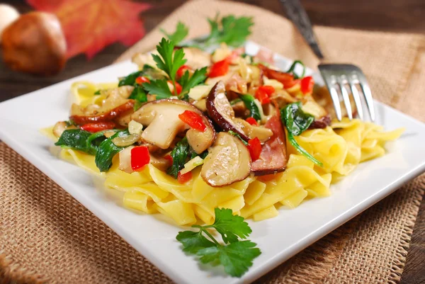 Tagliatelle com cogumelos porcini e espinafre — Fotografia de Stock