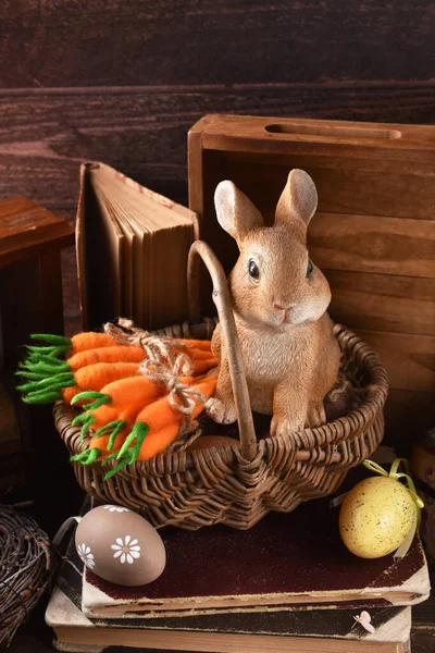 Tatlı tavşan heykelciği ve sepetinde keçeli havuç demetleriyle taşra tarzı Paskalya dekorasyonu.