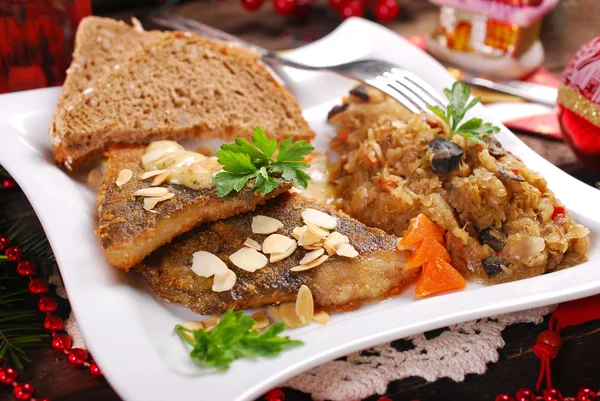 Fried carp with almonds and sauerkraut for christmas eve — Stock Photo, Image