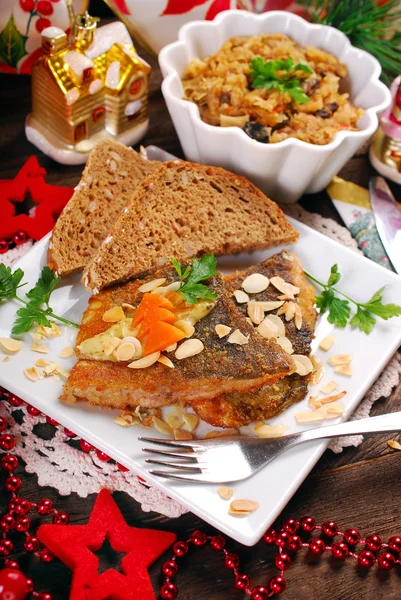 Fried carp with almonds and sauerkraut for christmas eve — Stock Photo, Image