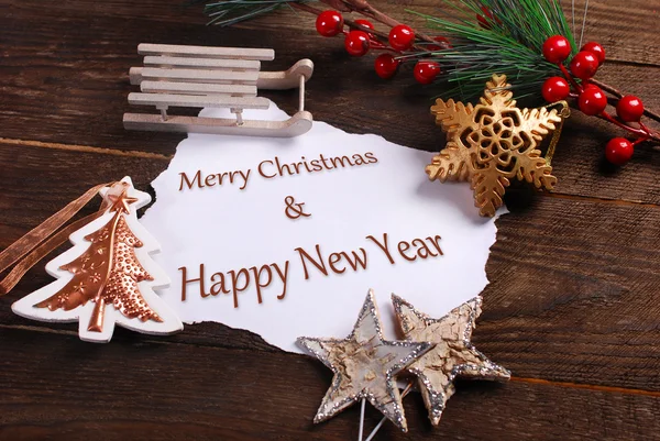 Tarjeta de Navidad con varias decoraciones y saludos en madera — Foto de Stock