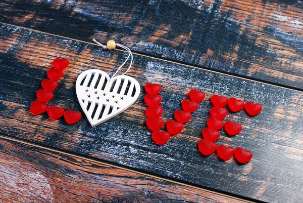 The word LOVE made of red candies and white heart — Stock Photo, Image