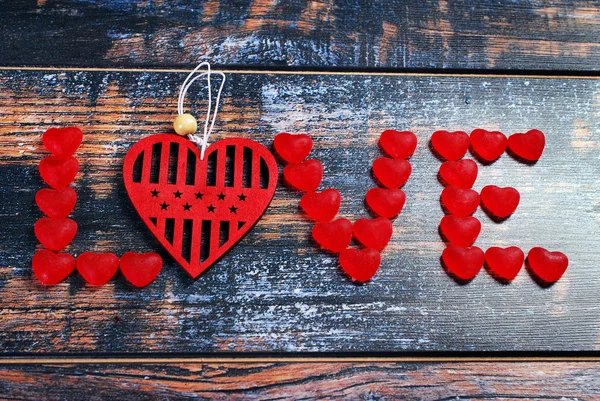 The word LOVE made of red candies and heart — Stock Photo, Image