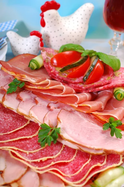 Platte mit gepökeltem Fleisch, Schinken und Salami auf dem Esstisch — Stockfoto
