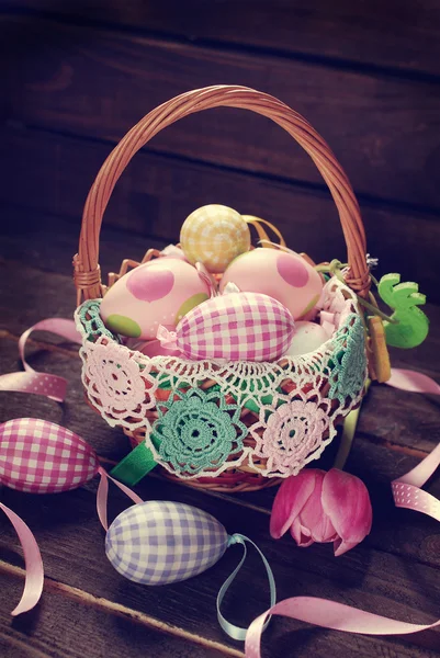 Wicker basket with colorful eggs for easter — Stock Photo, Image