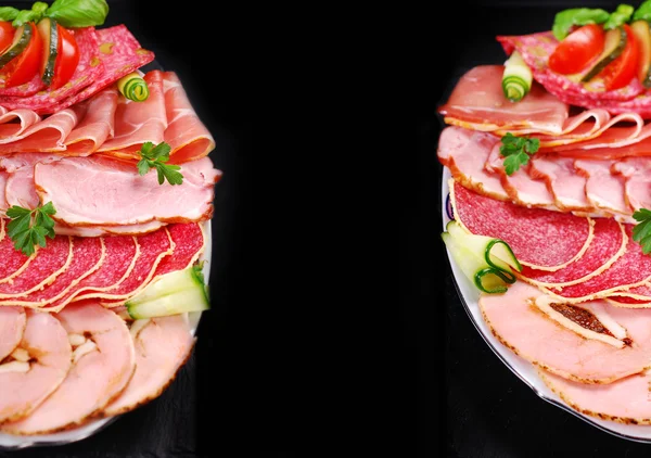 Due piatti di prosciutto affettato, salumi e salumi su dorso nero — Foto Stock