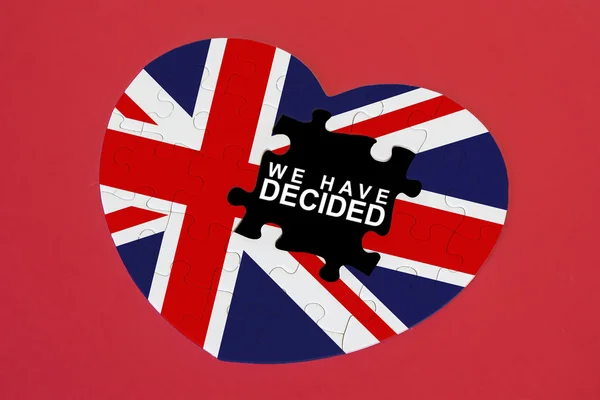 Heart shape United Kingdom Flag jigsaw puzzle with a written word We have Decided with red background. Brexit UK EU referendum concept — Stock Photo, Image