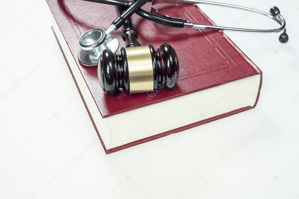 Gavel, stethoscope and book on white background