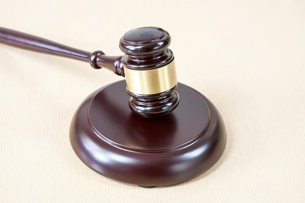 A wooden gavel on wooden table, on brown background — Stock Photo, Image