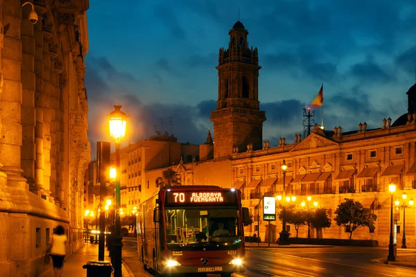 Bâtiments historiques éclairés de la ville, Lumières et bus de ville solitaire dans la rue . — Photo