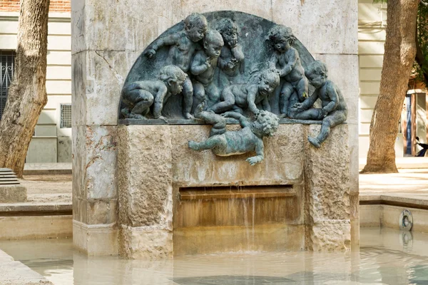 Sculpture and Fountane in Valencias Square: Children throw another child into the water. — Stock Photo, Image