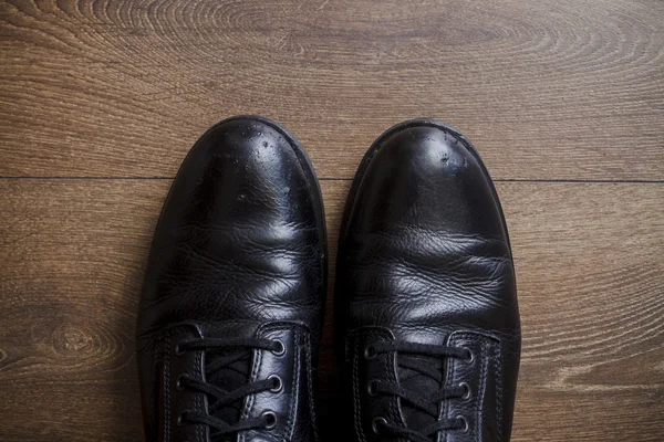 Bruin lederen schoenen op een houten vloer — Stockfoto