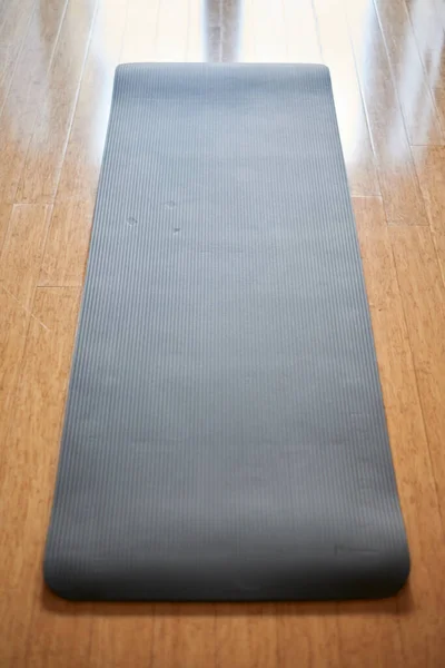 A studio photo of a black yoga mat