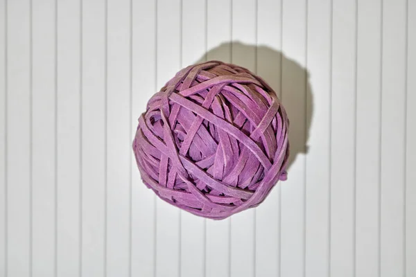 A studio photo of a rubber band ball