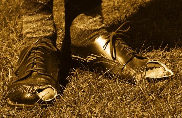 Pies en zapatos con agujeros en ellos — Foto de Stock