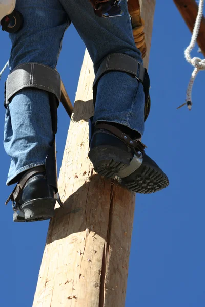 Lineman elétrico trabalhando em um pólo — Fotografia de Stock