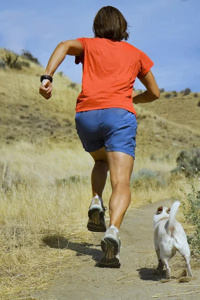 Girl running with white dog — Stock Photo, Image