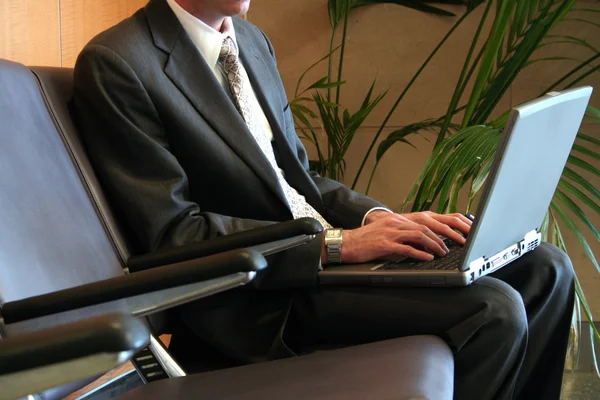 Man in een luchthaven met laptop — Stockfoto