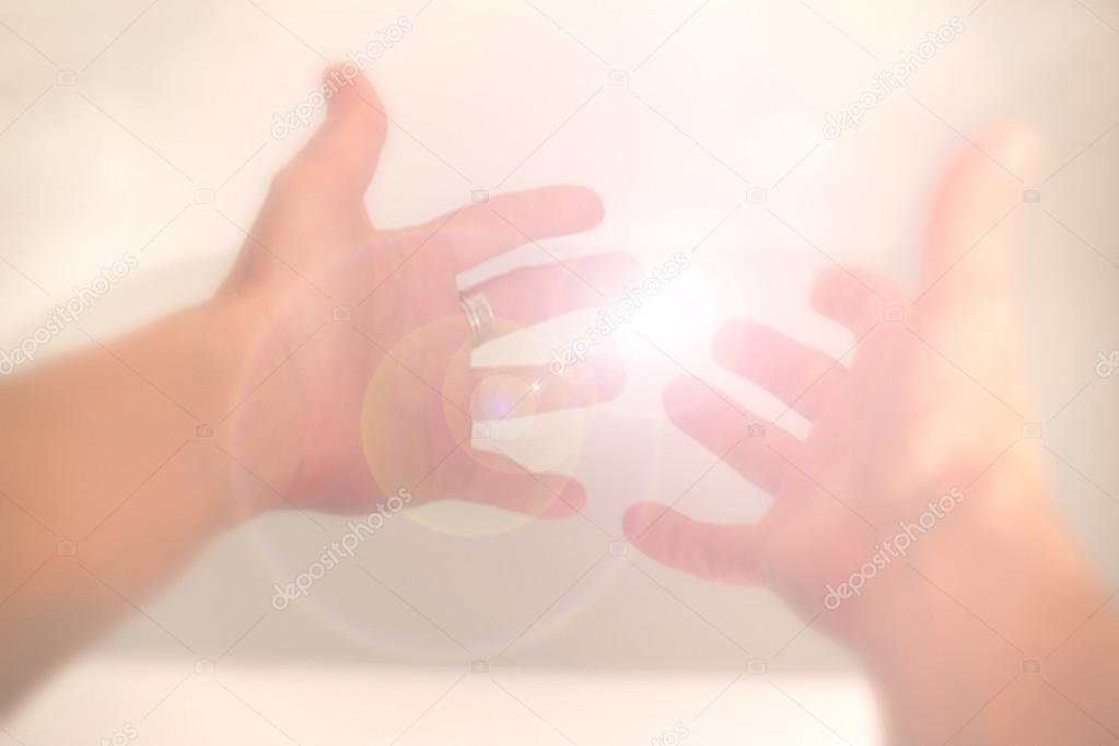 Hands reaching towards light