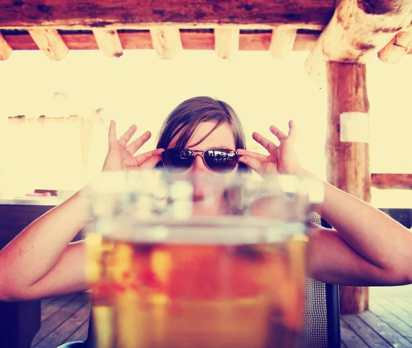 Woman peeking over draft beer