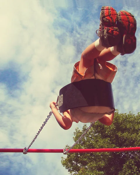 Boy swinging in playground — Stock Photo, Image