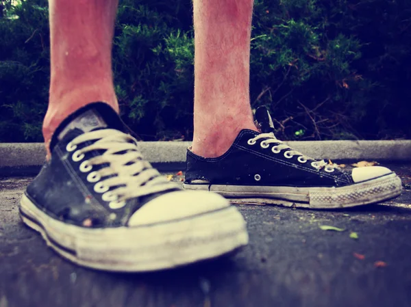 Pair of low top sneakers on pavement — Stock Photo, Image