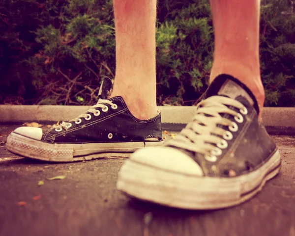 Pair of low top sneakers on pavement — Stock Photo, Image