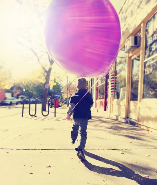 Pojke som springer med ballong — Stockfoto