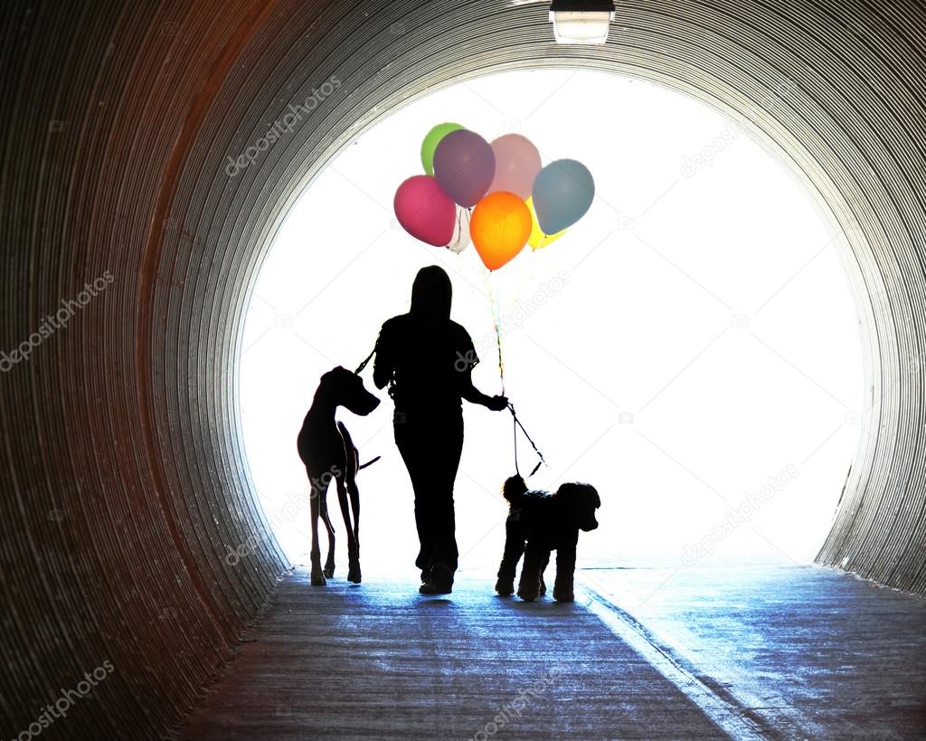 Girl holding balloons and two dogs