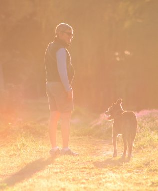 Köpeğiyle yürüyen bir kadın.