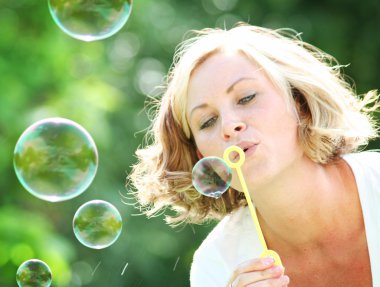 Kadın parkta kabarcıklar üfleme