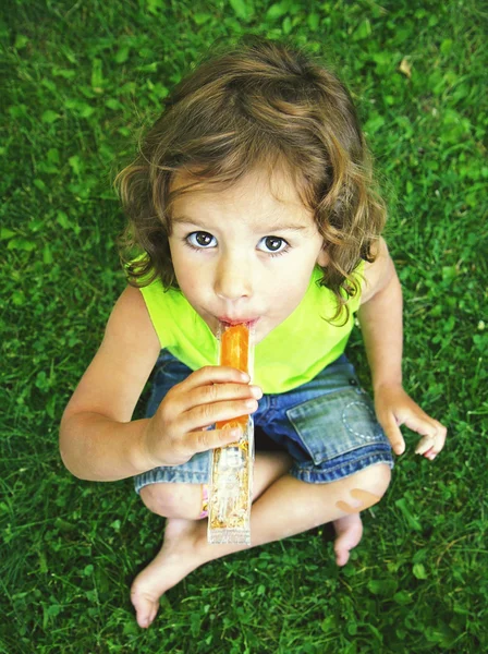 Young girl eating a frozen treat