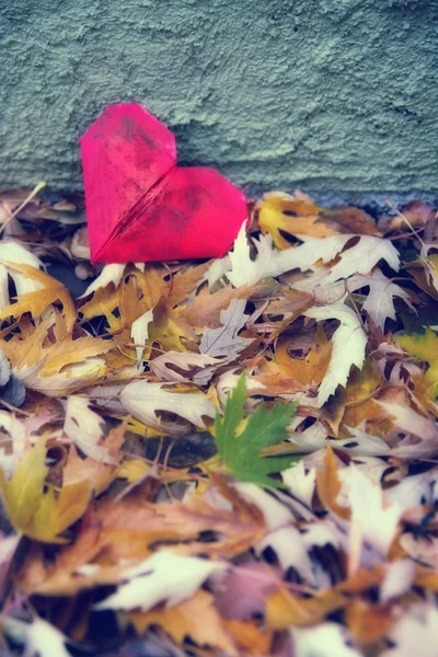 Corazón de papel en un montón de hojas —  Fotos de Stock