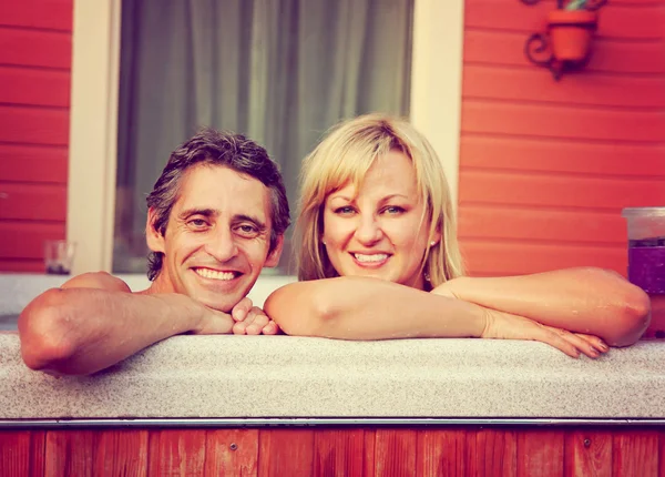 年轻夫妇坐在热水浴缸 — 图库照片