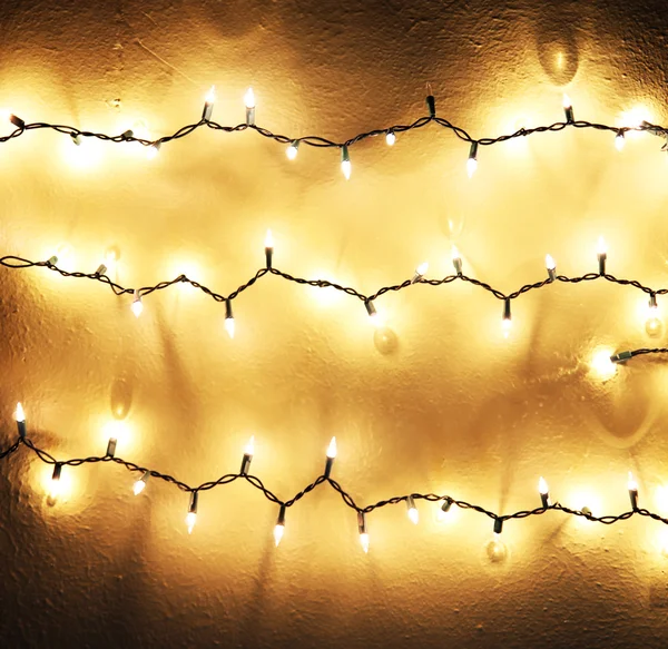 Luces chistmas brillantes colgando en la pared —  Fotos de Stock