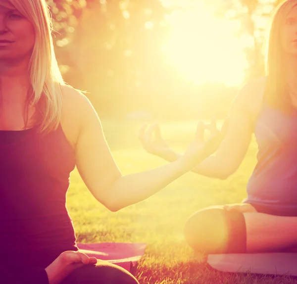 Duas mulheres meditando em uma pose de ioga — Fotografia de Stock