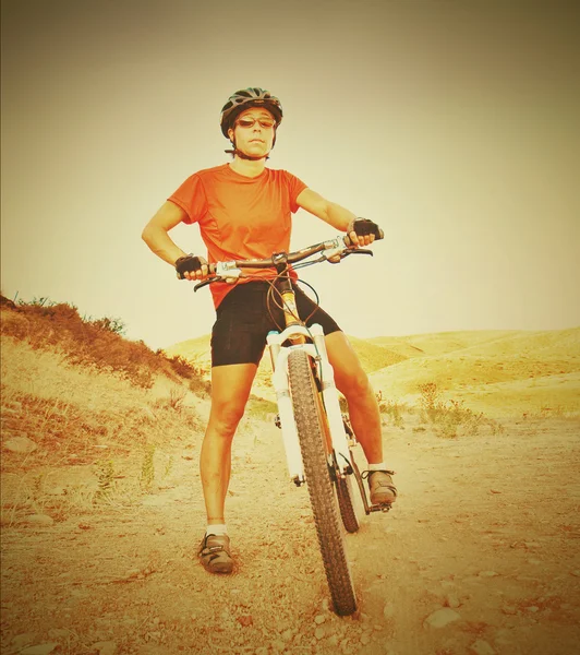 Meisje op fiets in heuvels — Stockfoto