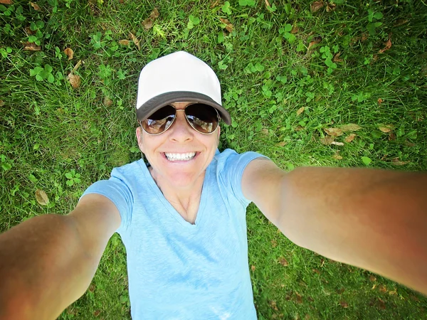 Girl in grass smiling at camera — Stock Photo, Image