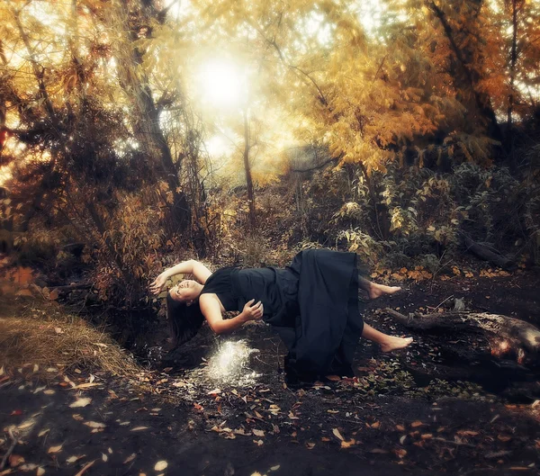 Woman floating above a small stream — Stock Photo, Image
