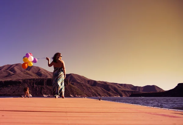 Kadın üstünde rıhtım balonlar ile — Stok fotoğraf