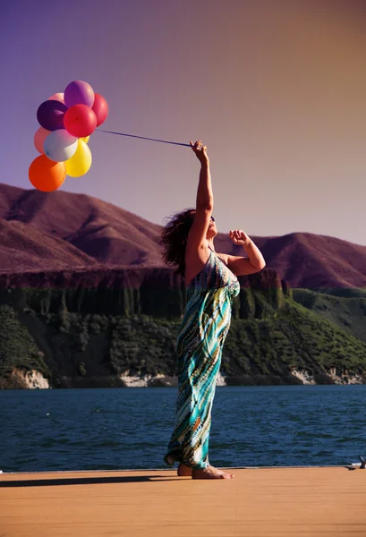 Kadın üstünde rıhtım balonlar ile — Stok fotoğraf