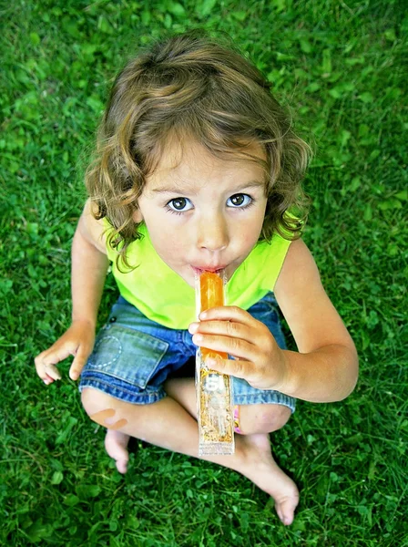 Dziewczynka jedzenie mrożony traktować — Zdjęcie stockowe